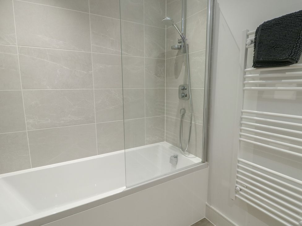 A bathroom featuring a shower over a bathtub at Glynllifon 5 in Marian-glas near Benllech