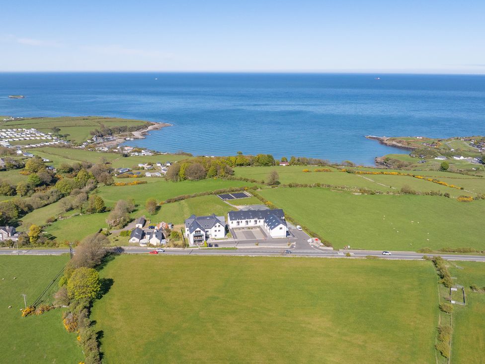 An aerial view of houses and fields near the ocean at Glynllifon 5 Marian-glas near Benllech