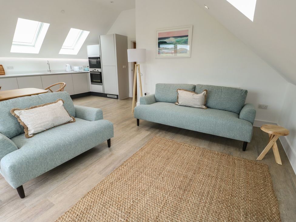 A living room with sofas and a table at Glynllifon 7 Marian-glas near Benllech