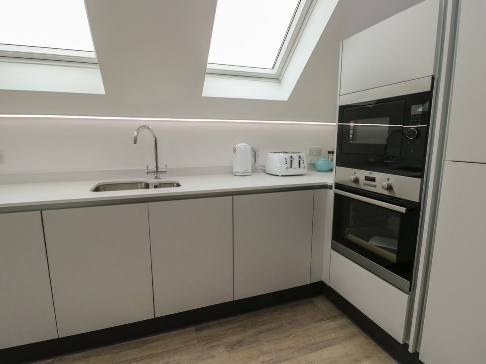 A kitchen with a sink and appliances at Glynllifon 7 Marian-glas near Benllech