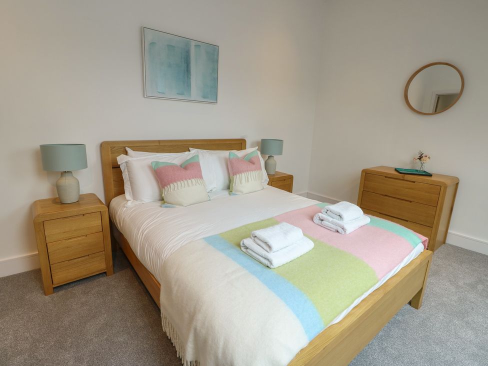 A bedroom with a bed and nightstands at Glynllifon 7 Marian-glas near Benllech