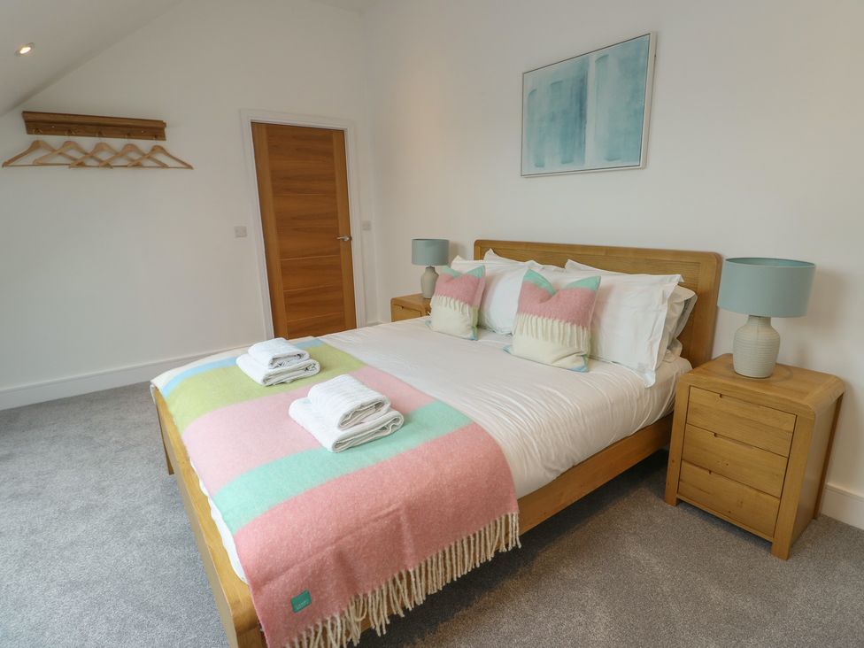 A bedroom with a bed and bedside tables at Glynllifon 7 Marian-glas near Benllech