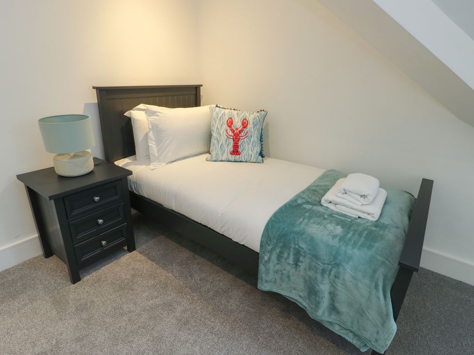 A bedroom with a single bed and bedside table at Glynllifon 7 Marian-glas near Benllech