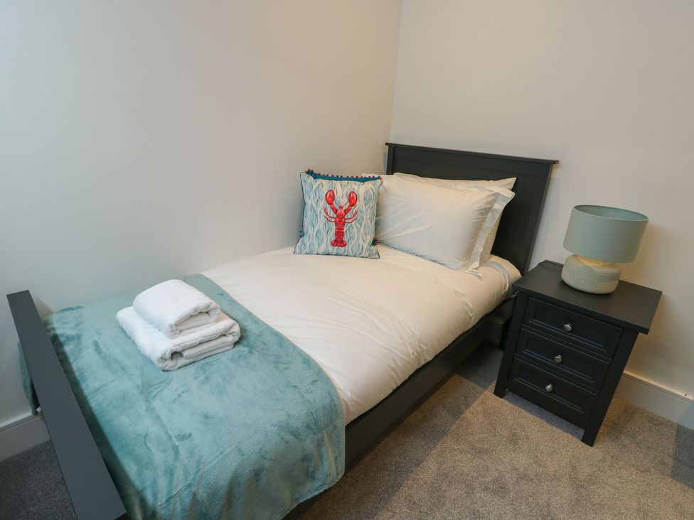 A bedroom with a single bed and bedside table at Glynllifon 7 Marian-glas near Benllech