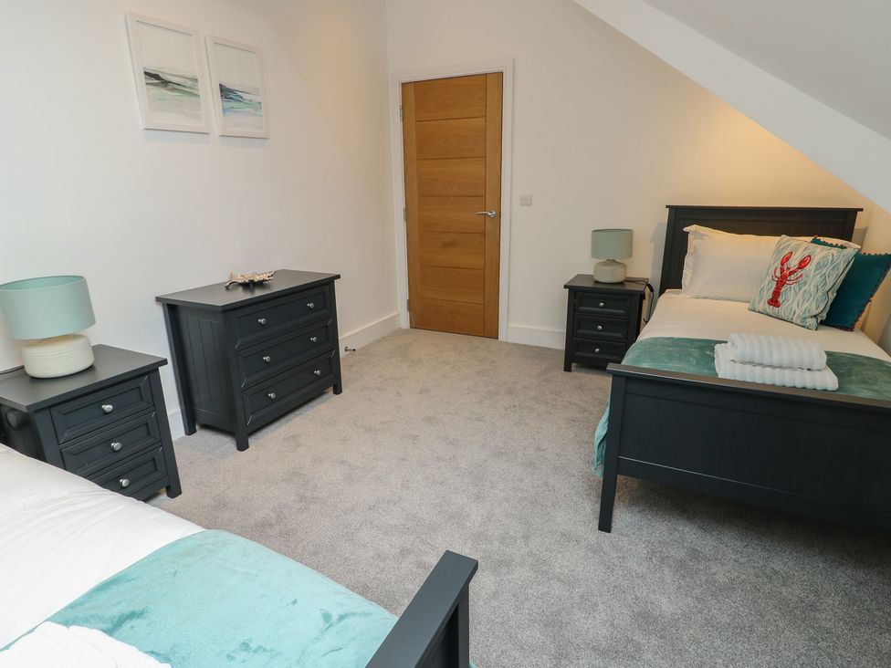 A bedroom with two beds and nightstands at Glynllifon 7 Marian-glas near Benllech