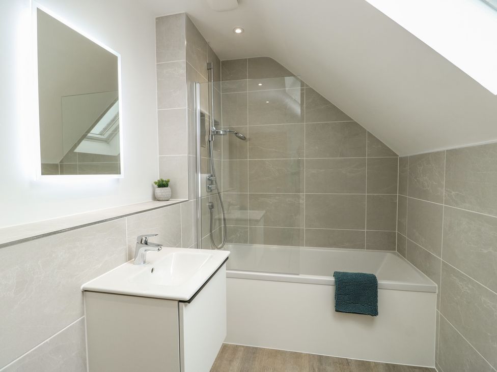 A bathroom with a shower and bathtub at Glynllifon 7 Marian-glas near Benllech