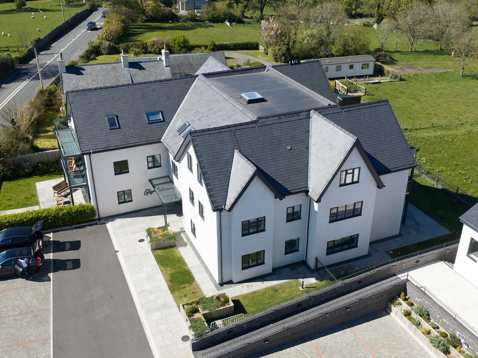 An aerial view of a building with cars in a parking lot at Glynllifon 7 Marian-glas near Benllech