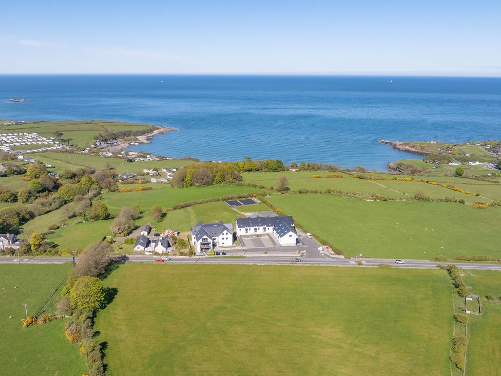 A coastal landscape with houses and fields at Glynllifon 7 Marian-glas near Benllech