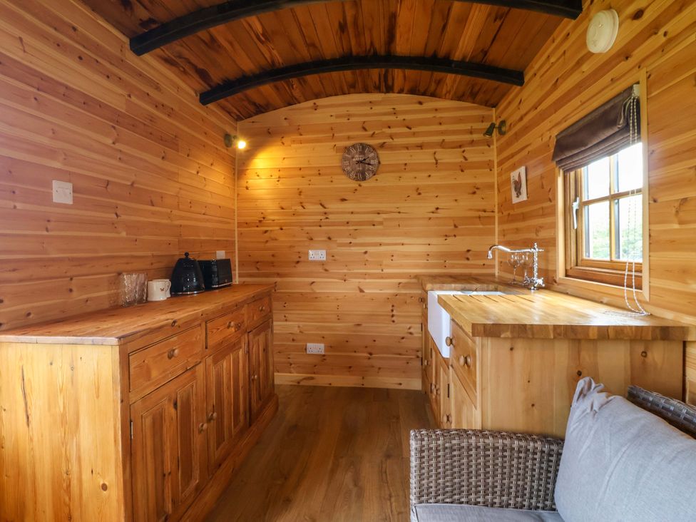 A kitchen with wooden cabinets and a sink at The Damselfly