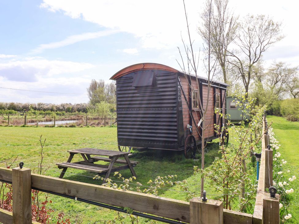 A caravan with a picnic table and trees at The Damselfly in 
