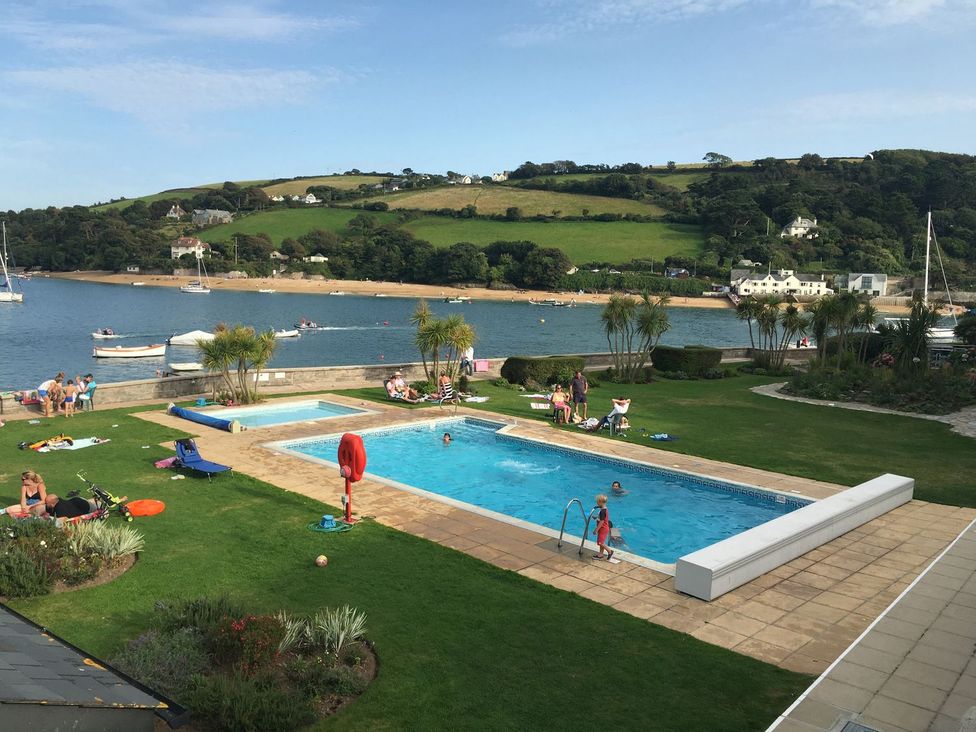 An outdoor swimming pool with people enjoying at 24 The Salcombe in Salcombe