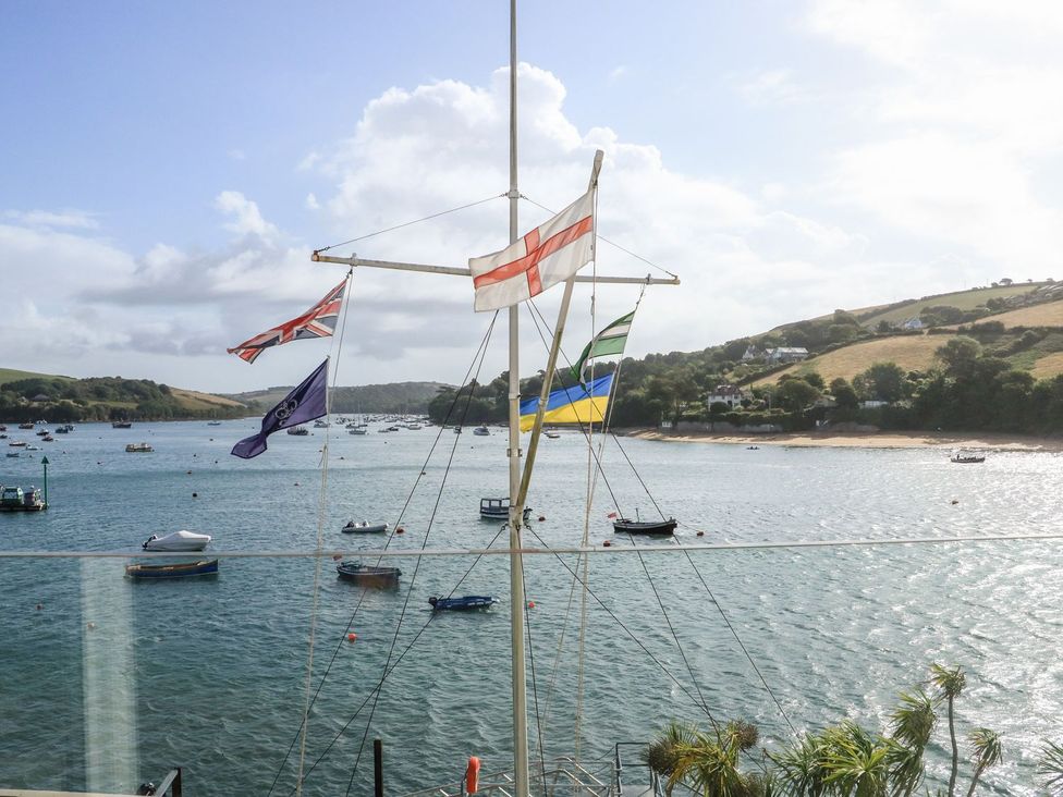 A view of flags and boats on water at 24 The Salcombe in Salcombe