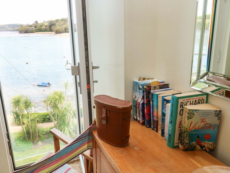A table with books and a suitcase overlooking the water at 24 The Salcombe Salcombe