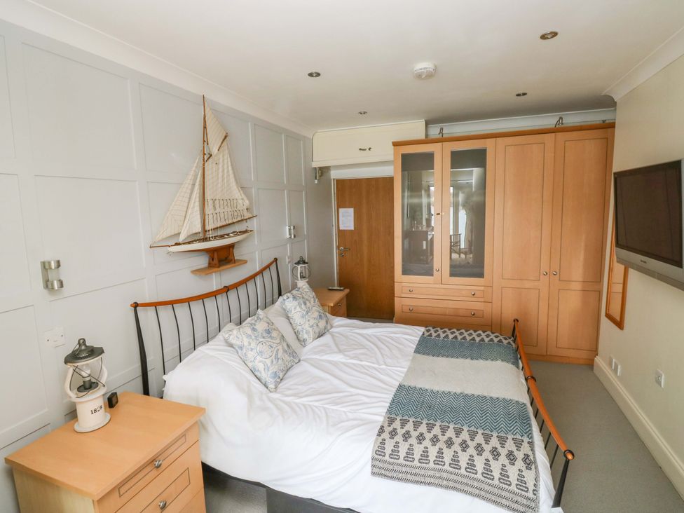 A bedroom with a bed and wardrobe at 24 The Salcombe in Salcombe