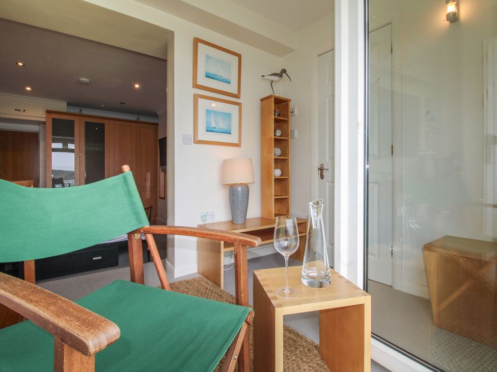 A snug area with a chair and side table at 24 The Salcombe in Salcombe