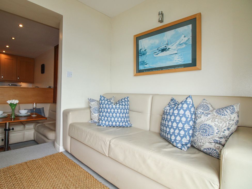 A living room with a sofa and dining table at 24 The Salcombe in Salcombe