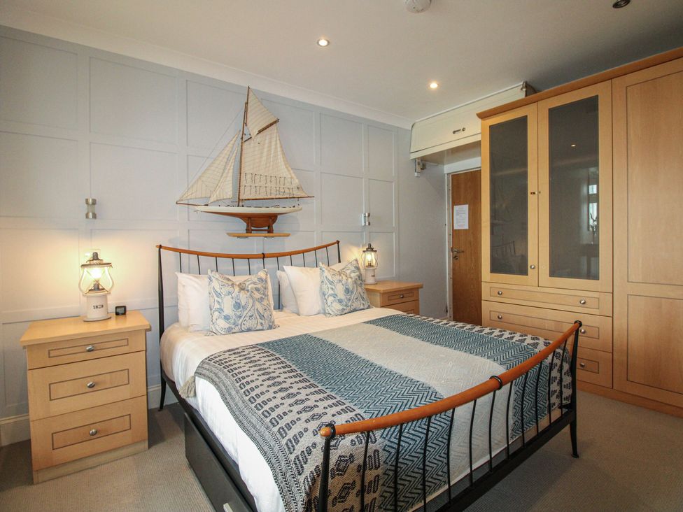 A bedroom with a bed and nightstands at 24 The Salcombe Salcombe