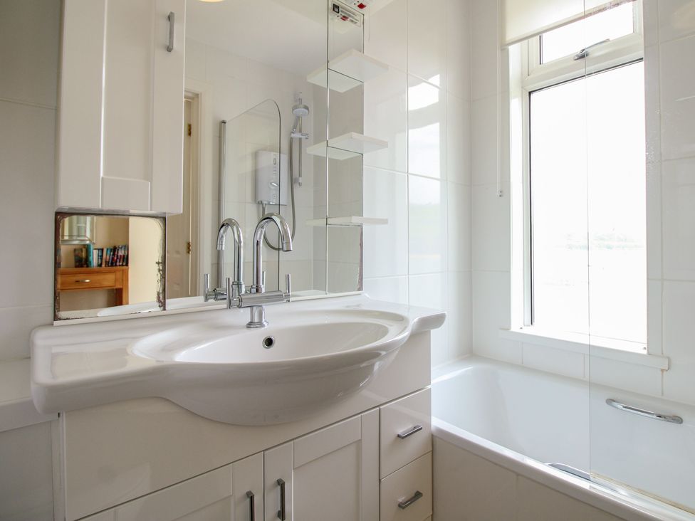 A bathroom with a sink and bathtub at 24 The Salcombe in Salcombe