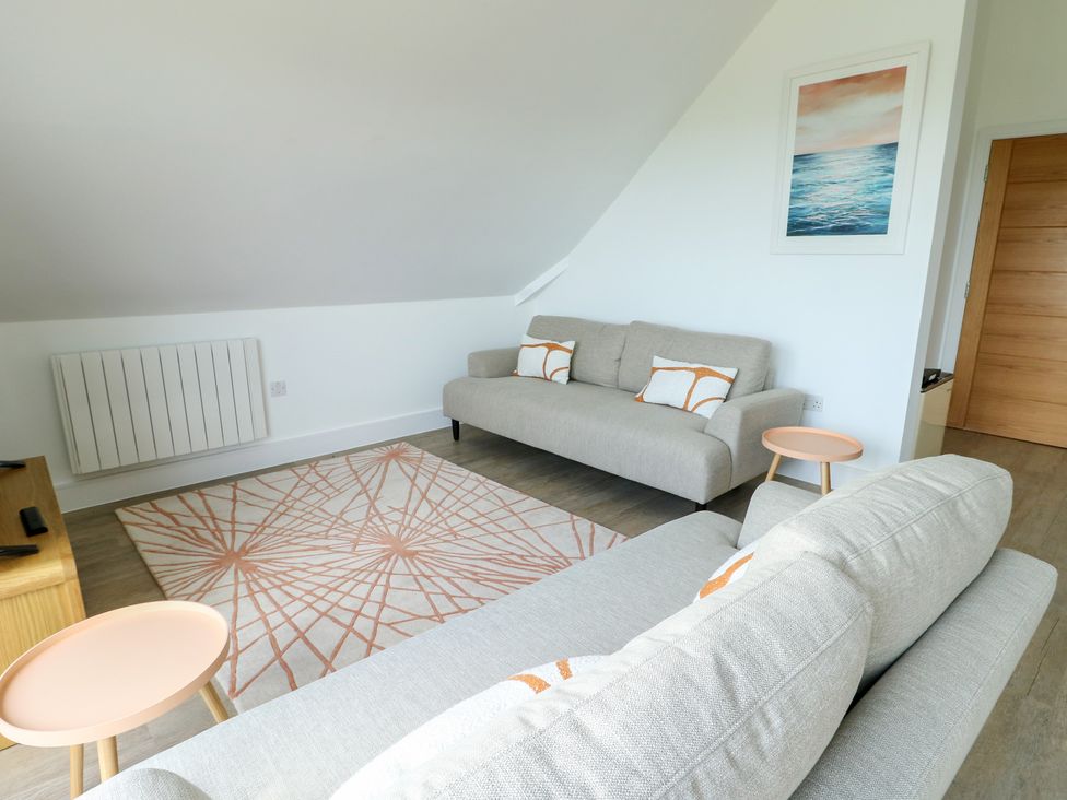 A living room with two sofas and a rug at Glynllifon 8 Marian-glas near Benllech