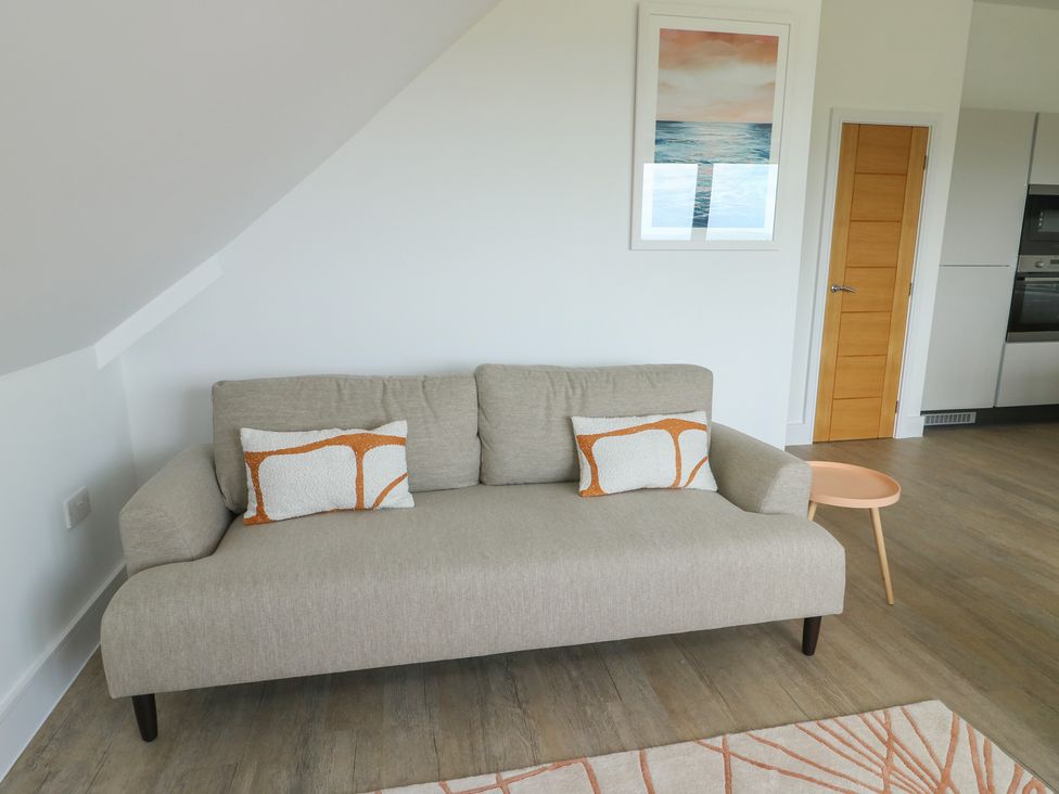 A living room with a sofa and side table at Glynllifon 8 in Marian-glas near Benllech