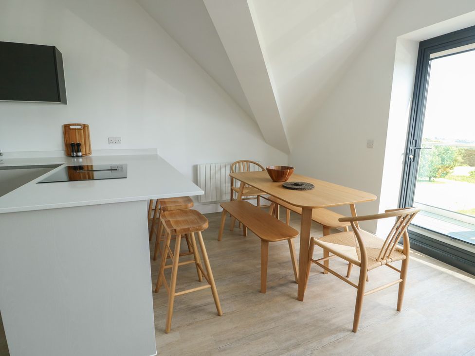 A kitchen with a dining table and chairs at Glynllifon 8 Marian-glas near Benllech