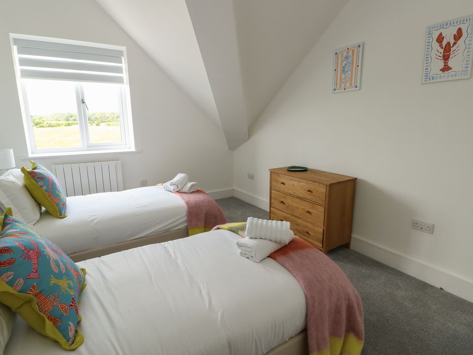 A bedroom with two beds and a chest of drawers at Glynllifon 8 Marian-glas near Benllech