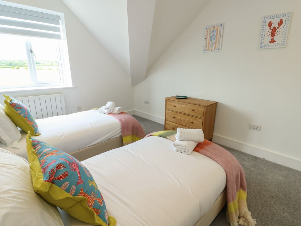 A bedroom with two single beds and a wooden dresser at Glynllifon 8 Marian-glas near Benllech