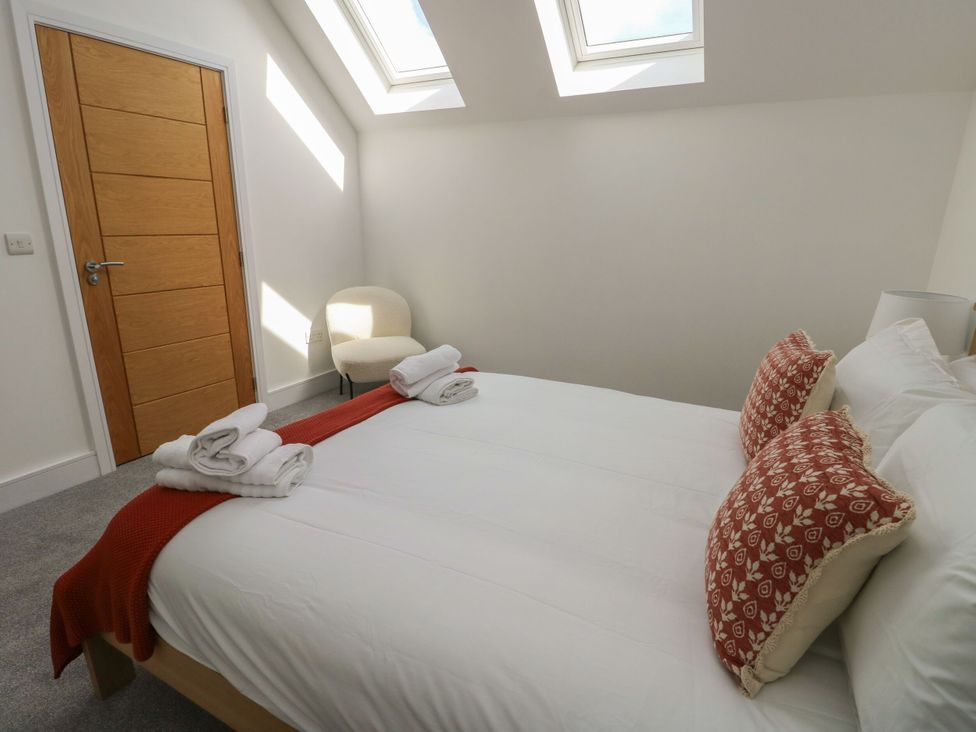 A bedroom with a bed and chair at Glynllifon 8 Marian-glas near Benllech