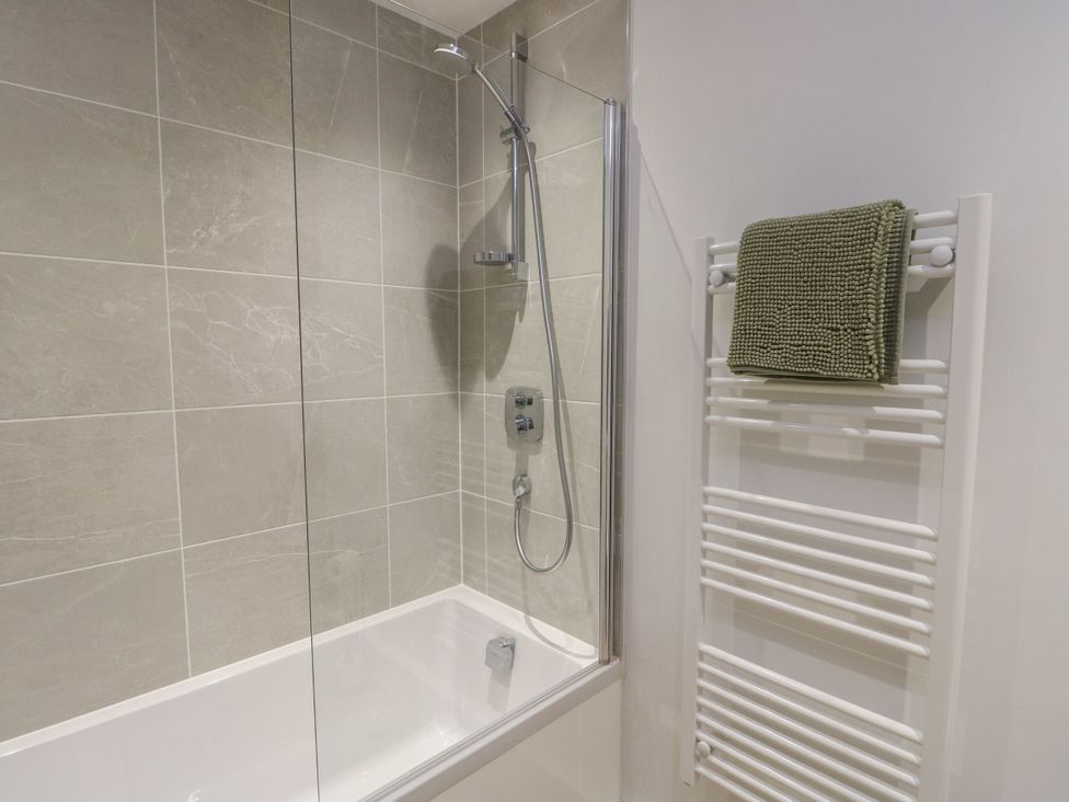 A bathroom with a shower and bathtub at Glynllifon 8 Marian-glas near Benllech
