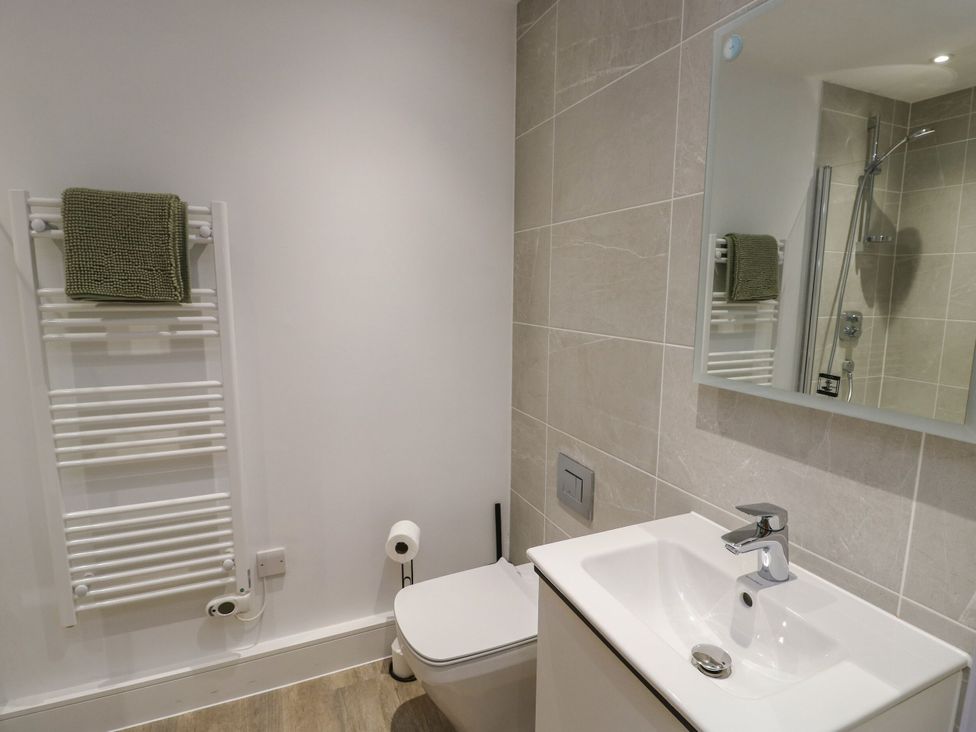 A bathroom with a sink, toilet, and towel rack at Glynllifon 8, Marian-glas near Benllech