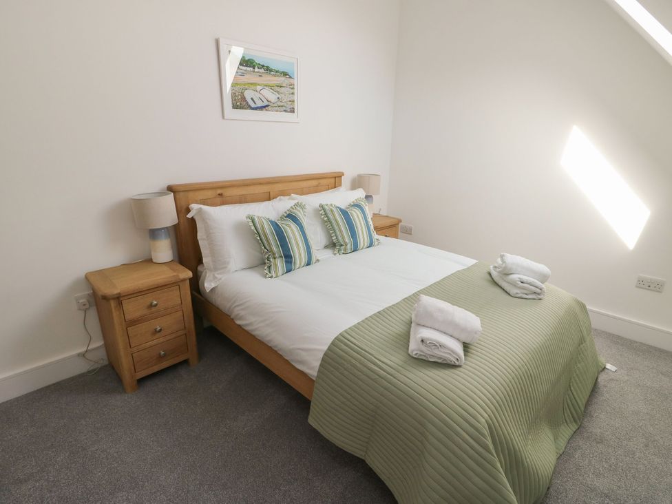 A bedroom with a double bed and bedside tables at Glynllifon 8 Marian-glas near Benllech