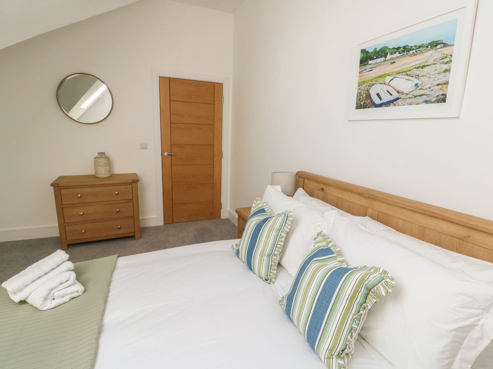 A bedroom with a bed and dresser at Glynllifon 8 Marian-glas near Benllech