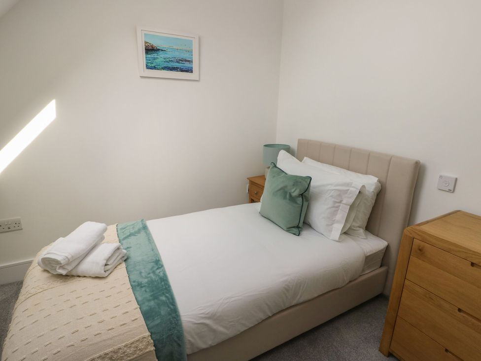 A bedroom with a bed and bedside table at Glynllifon 8 Marian-glas near Benllech