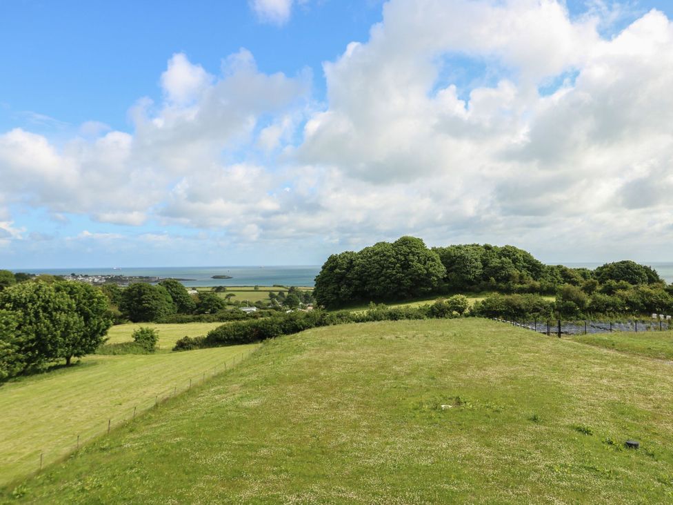 A view of grass and trees overlooking the ocean at Glynllifon 9 Marian-glas near Benllech