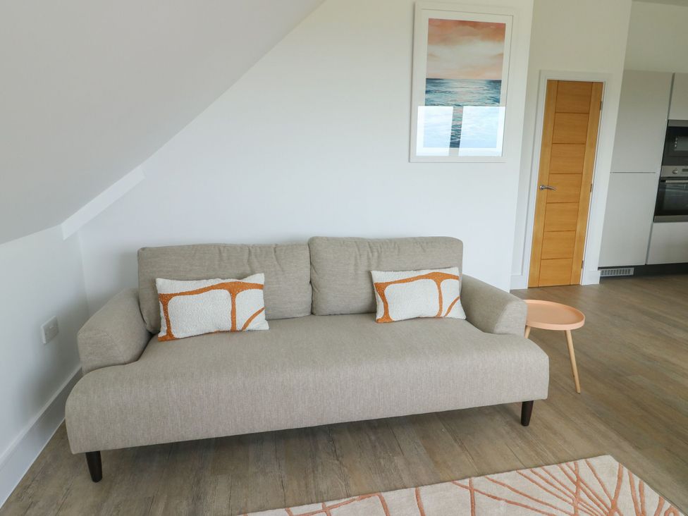 A living room with a sofa and table at Glynllifon 9 Marian-glas near Benllech