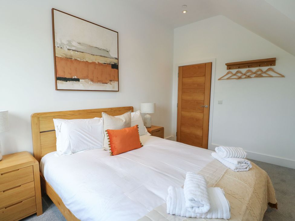 A bedroom with a bed and artwork at Glynllifon 9 Marian-glas near Benllech