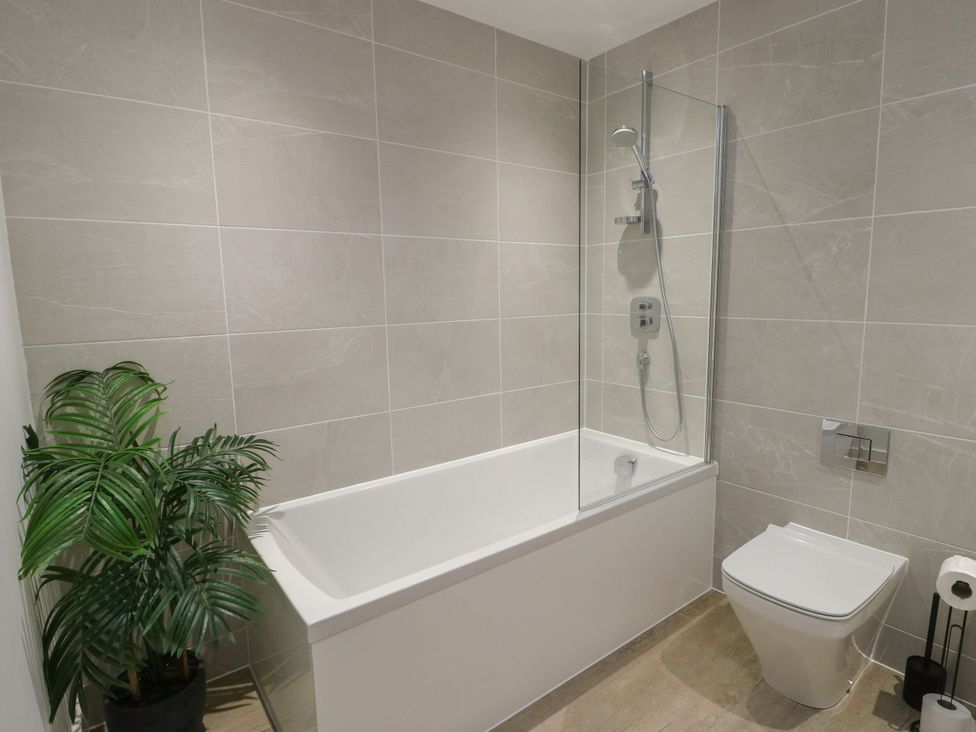 A bathroom with a bathtub and shower at Glynllifon 9 Marian-glas near Benllech