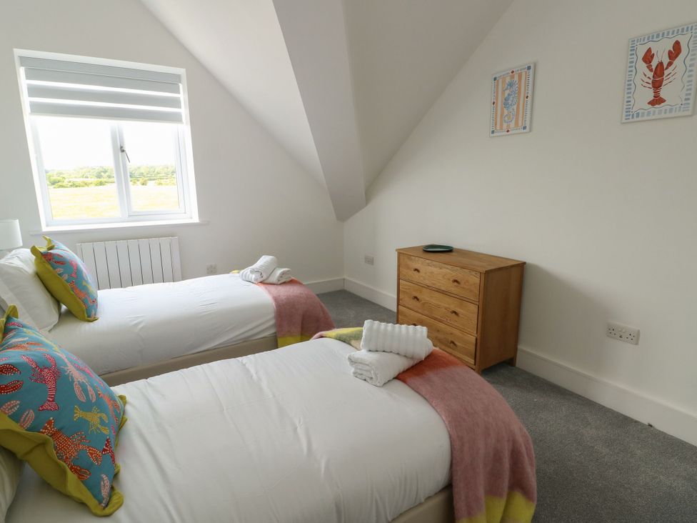 A bedroom with two single beds and a dresser at Glynllifon 9 Marian-glas near Benllech