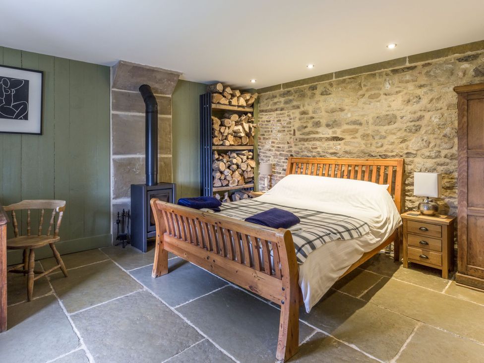 A bedroom with a bed and fireplace at Orchard Cottage in Durham
