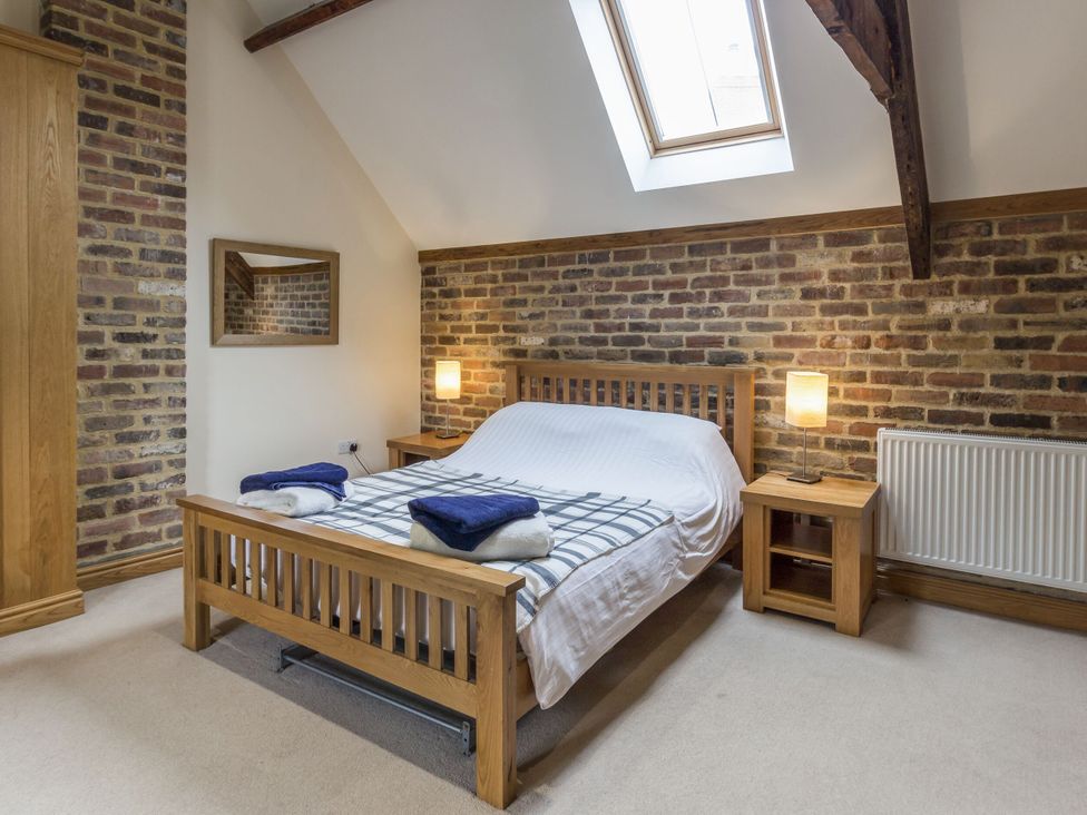 A bedroom with a bed and bedside table at Orchard Cottage in Durham