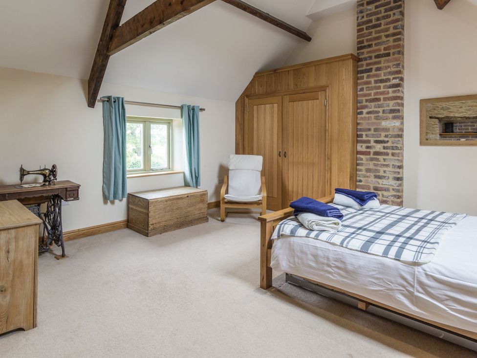 A bedroom with a bed and wardrobe at Orchard Cottage Durham