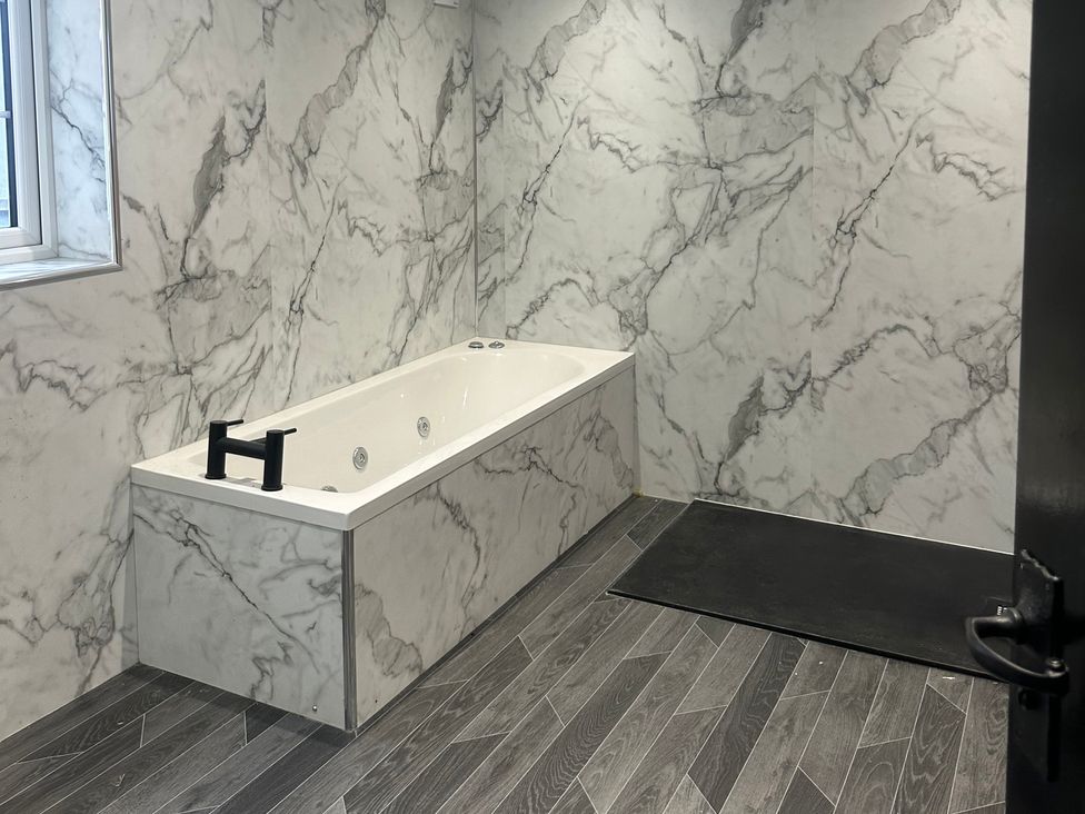 A bathroom with a bathtub and window at Sugar loft in Silloth