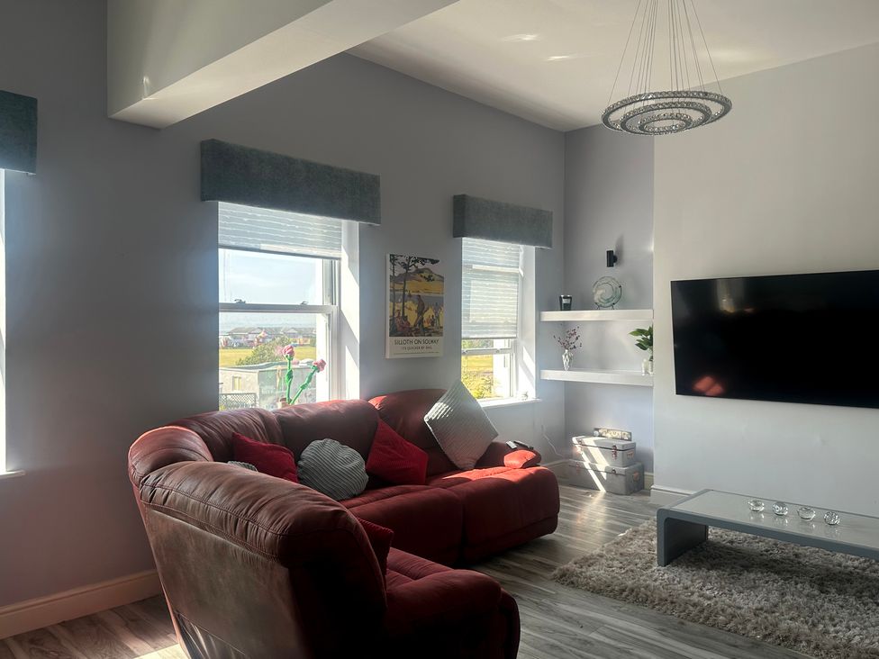 A living room with a sofa and a television at Sugar loft in Silloth