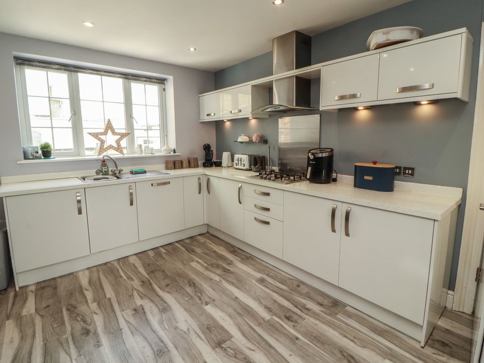 A kitchen with cabinets and appliances at Sugar Loft in Silloth