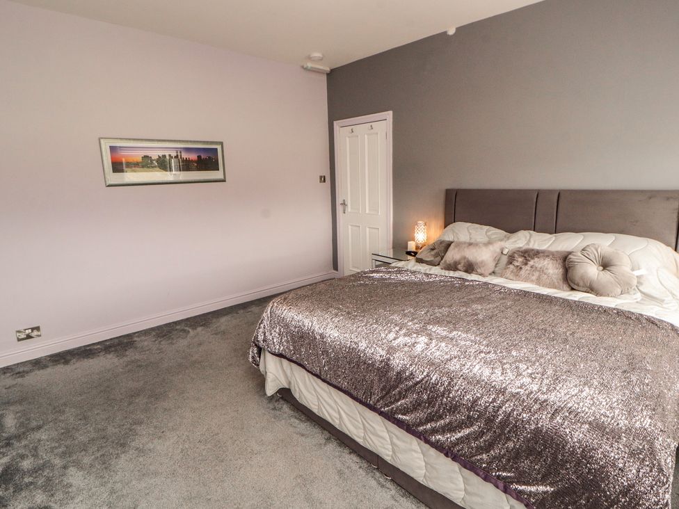 A bedroom with a bed and wall art at Sugar Loft in Silloth