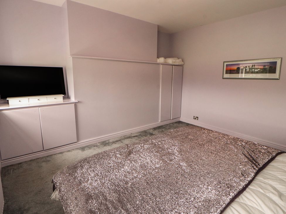 A bedroom with a television and a wardrobe at Sugar Loft in Silloth
