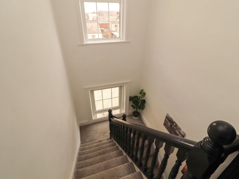 A staircase with windows and a plant at Sugar Loft in Silloth