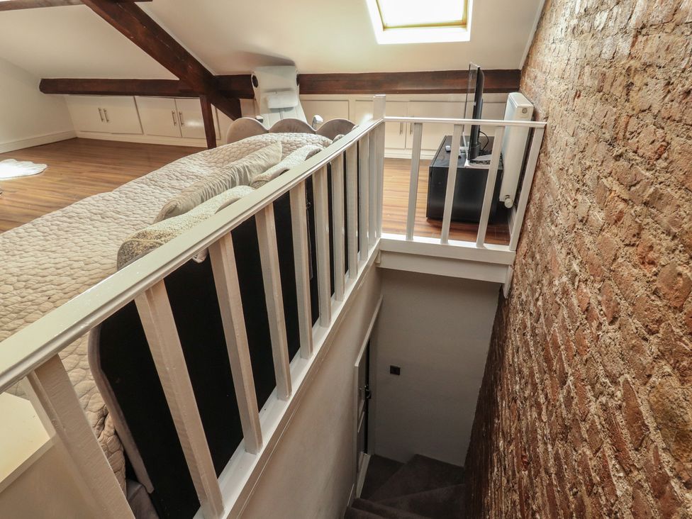 A loft with a skylight and staircase at Sugar Loft in Silloth