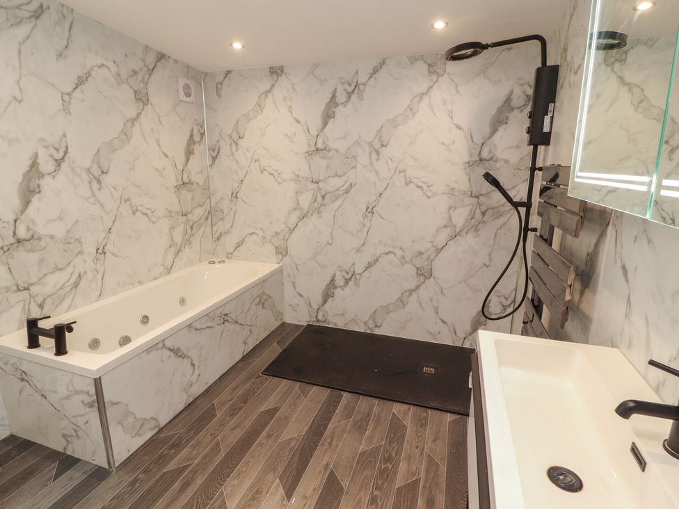 A bathroom with a bathtub and sink at Sugar Loft in Silloth