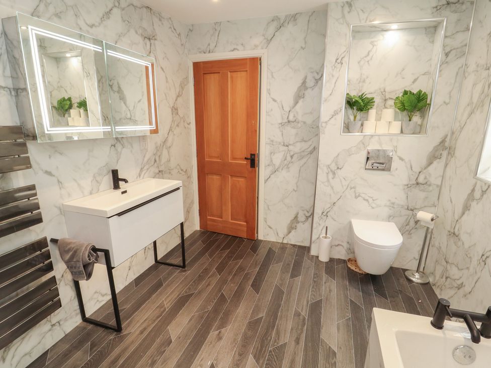 A bathroom with sink, toilet, and storage at Sugar Loft in Silloth